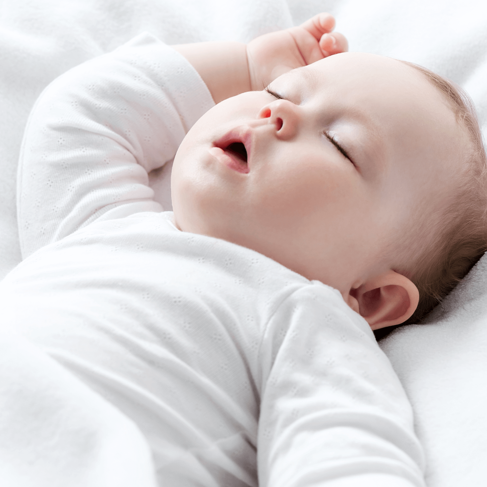 Baby lying fast asleep in the cot on a white cotton cot bed fitted sheet | Parenting tips & advice - Clair de Lune UK