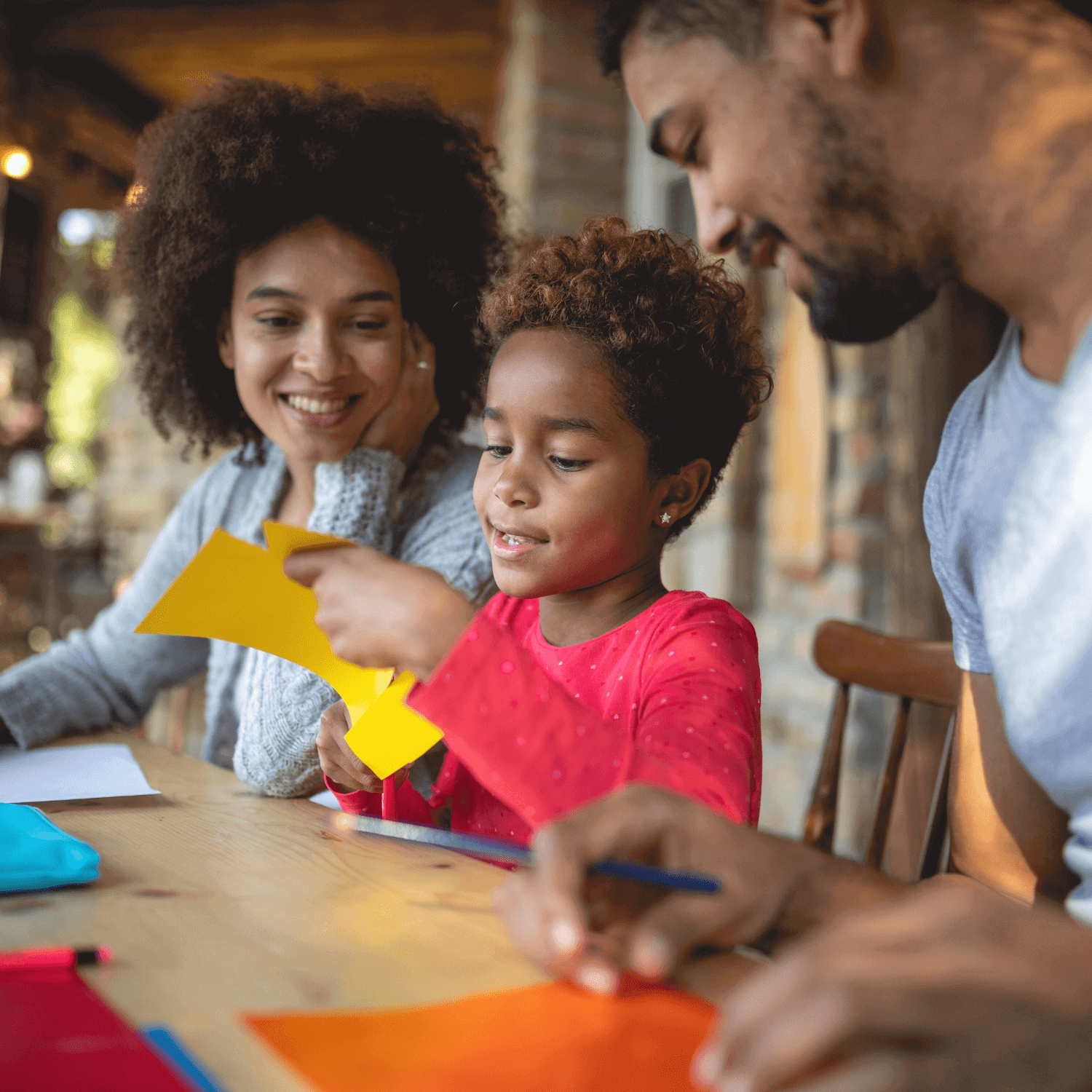 Family of mum, dad and son, creating and making art together at the table | The Role of Parents in Nurturing Creativity - Clair de Lune UK