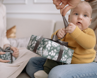 Baby say on mums knee on the floor opening a Christmas present | Family Christmas - Clair de Lune UK