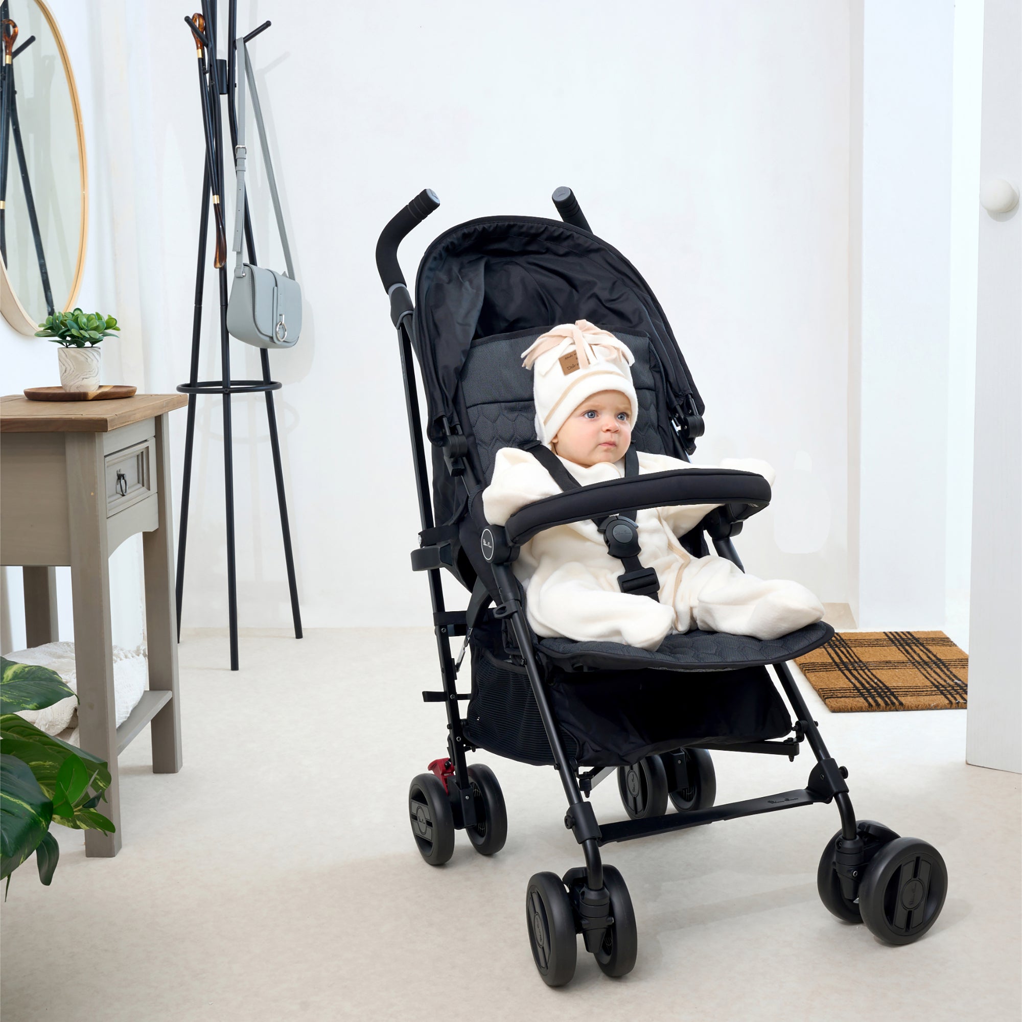Toddler sat in the pushchair wearing a cream Star Fleece Baby Wrap Blanket | Pushchair Accessories - Clair de Lune UK