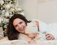 Mum and baby reading in front of the Christmas tree | Family Christmas - Clair de Lune UK