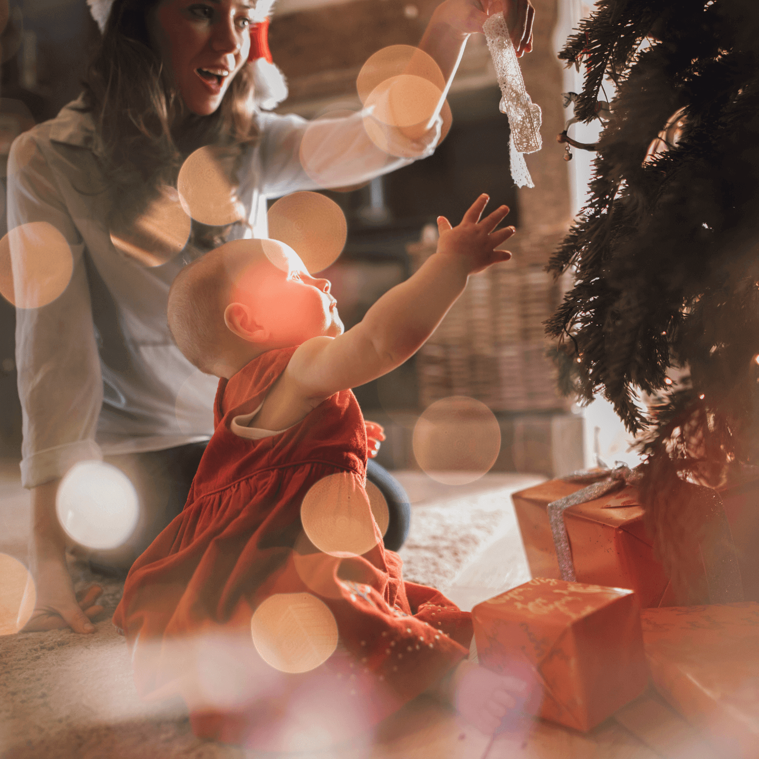 Baby Opening Presents under the Christmas tree with her mum | The Ultimate New Baby Gift Guide - Clair de Lune UK