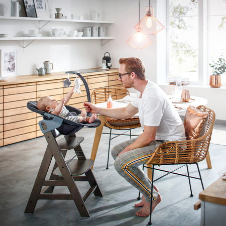 Dad feeding baby sitting on the Hauck Alpha+ Bouncer and High Chair Bundle | Highchairs | Feeding & Weaning - Clair de Lune UK