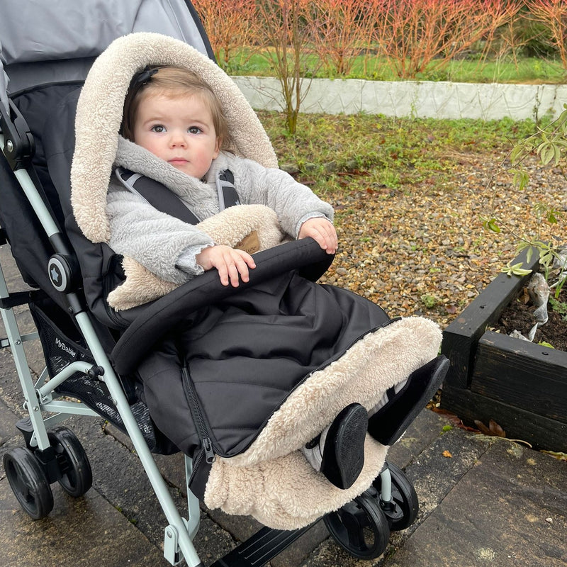  Toddler snuggling in the Black Snug Pushchair Footmuff | Pushchair Cosytoes & Footmuffs | Travel Accessories - Clair de Lune UK