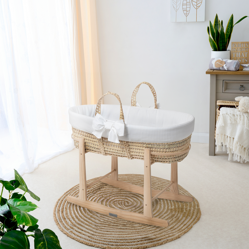 White 80th Anniversary Chelsea Palm Moses Basket on the Natural Standard Rocking Stand in a Scandi gender-neutral nursery | Moses Baskets and Stands | Co-sleepers | Nursery Furniture - Clair de Lune UK