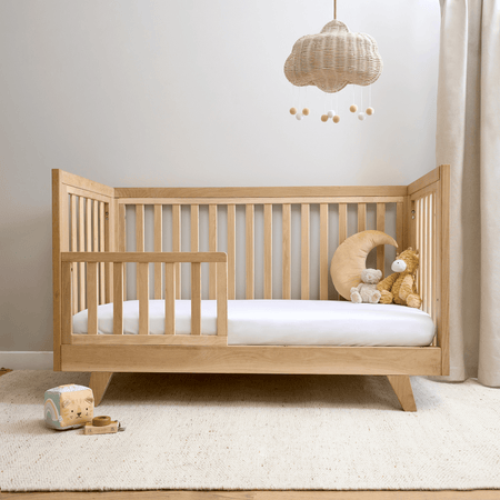 Oak Cot Bed transformed to a toddler bed with the toddler extension in a Scandi Natural Nursery Room | Cots, Cot Beds, Toddler & Kid Beds | Nursery Furniture - Clair de Lune UK