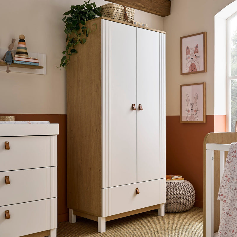 The white and natural double wardrobe of the White and Natural CuddleCo Rafi Nursery Room Sets in a Biritsh countryside cottage nursery room | Nursery Furniture Sets | Room Sets | Nursery Furniture - Clair de Lune UK