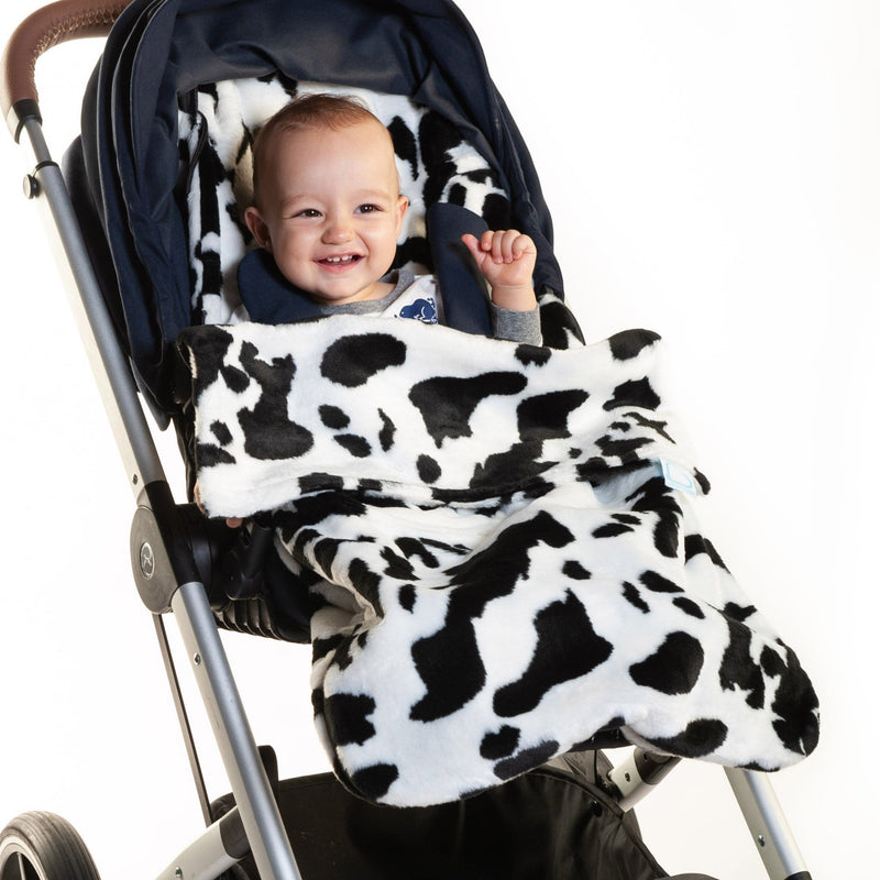 Smiling baby in the Black and White Cow Moo Buggysnuggle Snuggle Fur Footmuff | Pushchair Cosytoes & Footmuffs | Travel Accessories - Clair de Lune UK