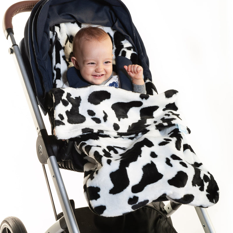 Happy baby in the Black and White Cow Moo Buggysnuggle Snuggle Fur Footmuff | Pushchair Cosytoes & Footmuffs | Travel Accessories - Clair de Lune UK