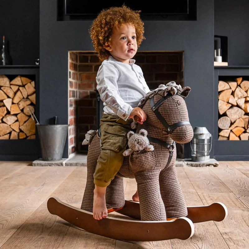 Toddler boy riding his Little Bird Told Me Chester & Fred Rocking Horse in a cosy dark grey living room | Rocking Animals | Montessori Activities For Babies & Kids | Toys | Baby Shower, Birthday & Christmas - Clair de Lune UK
