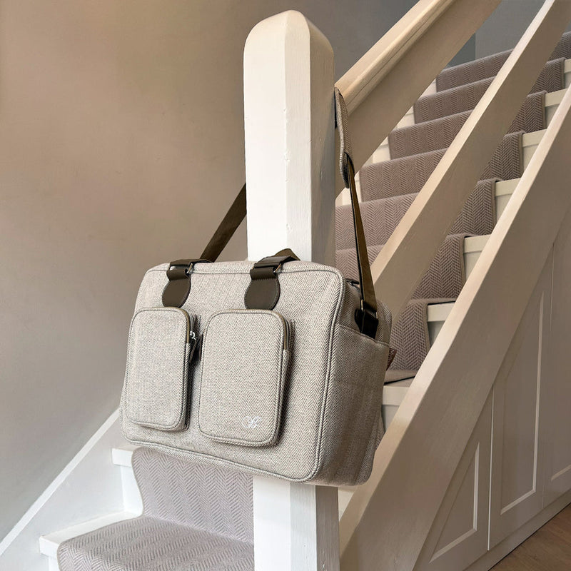 My Babiie Billie Faiers Oatmeal Herringbone Deluxe Changing Bag hanging next to the stair | Stylish Nappy Bags | Travel With Baby - Clair de Lune UK