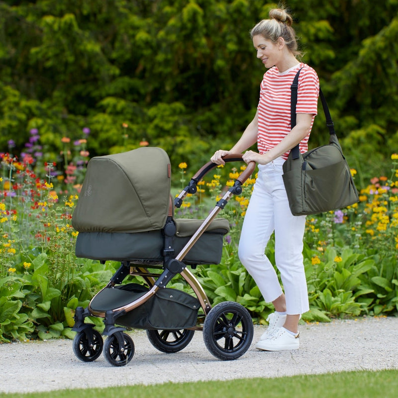 Mum wearing the included changing bag while pushing her Woodland Green Ickle Bubba Stomp V4 2 in 1 Pushchair & Carrycot | Pushchairs and Travel Systems | Baby & Kid Travel - Clair de Lune UK