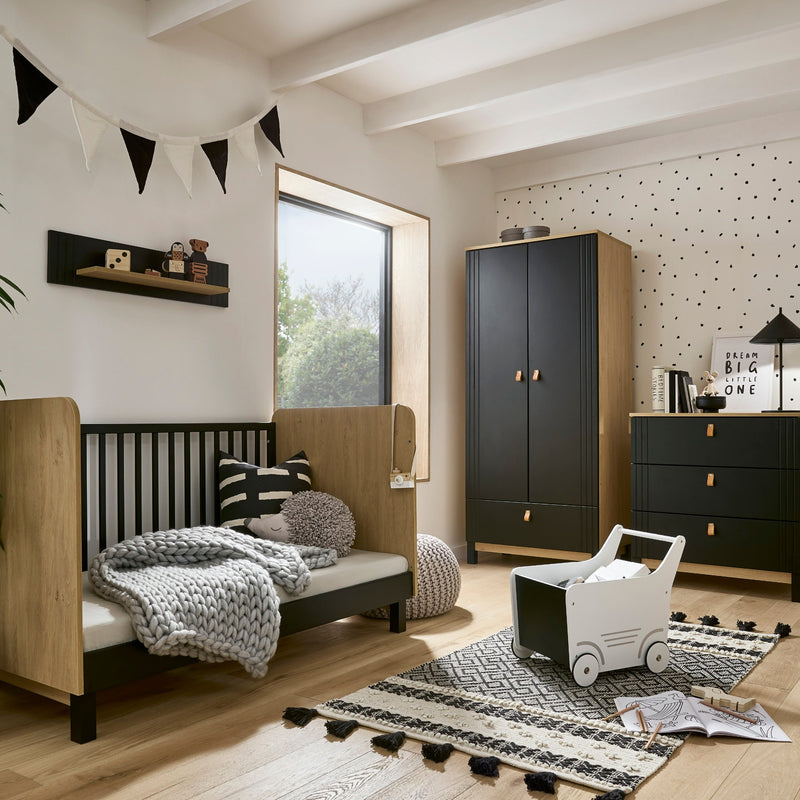 The 3-Piece Room Set including a black and natural cot bed, a matching double wardrobe and a matching dresser from the Black and Natural CuddleCo Rafi Nursery Room Sets with the cot bed transformed to a toddler bed in a monochrome style nursery furniture 
