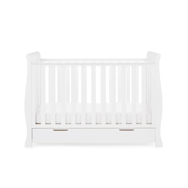 The white Obaby Stamford Mini Sleigh Cot Bed with an adjustable platform at the lowest level | Cots, Cot Beds, Toddler & Kid Beds | Nursery Furniture - Clair de Lune UK
