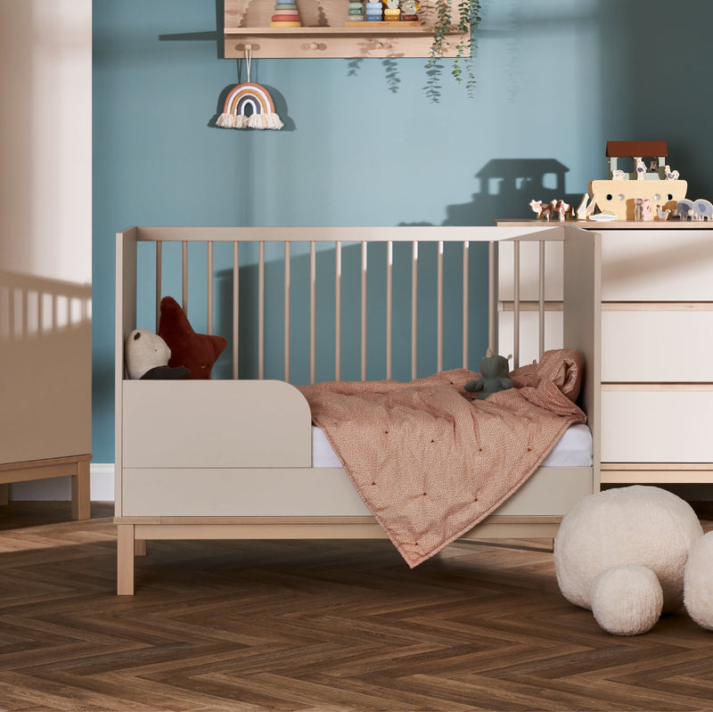 The Cashmere Natural Obaby Astrid Mini Cot Bed when transformed to a toddler bed next to a dresser in a pastel green Scandi jungle safari inspired nursery room | Cots, Cot Beds, Toddler & Kid Beds | Nursery Furniture - Clair de Lune UK