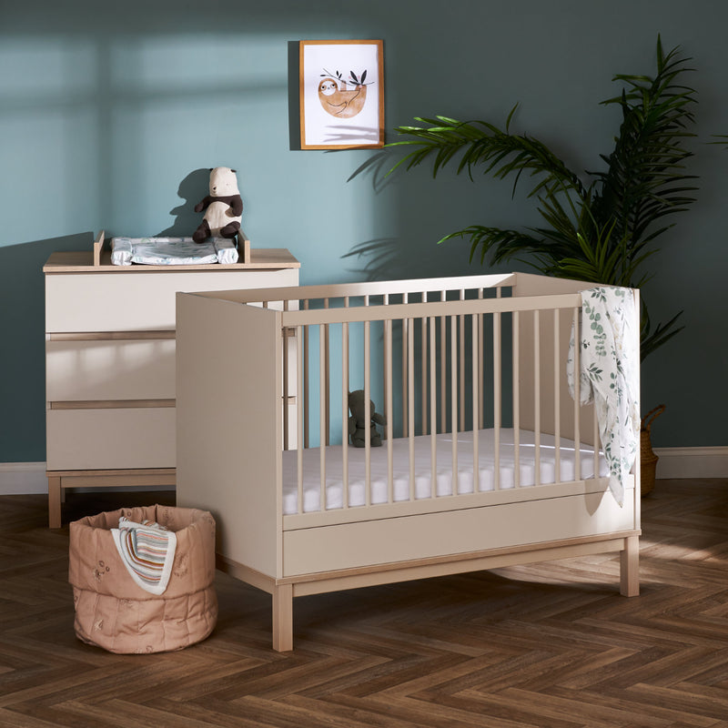 The Cashmere Natural Obaby Astrid Mini Cot Bed next to a dresser in a pastel green Scandi jungle safari inspired nursery room | Cots, Cot Beds, Toddler & Kid Beds | Nursery Furniture - Clair de Lune UK