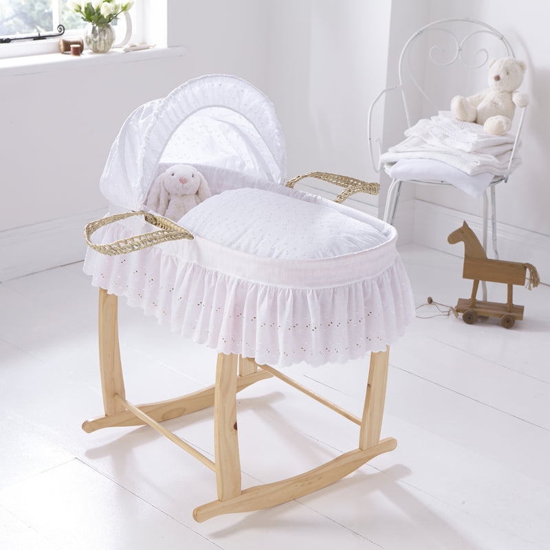 Broderie Anglaise Palm Moses Basket Bedding Set (With Skirt) on a palm Moses basket and a Natural Deluxe Rocking Stand in a white nursery room | Moses Basket Dressings | Nursery Bedding & Decor Collections | Nursery Inspiration - Clair de Lune UK