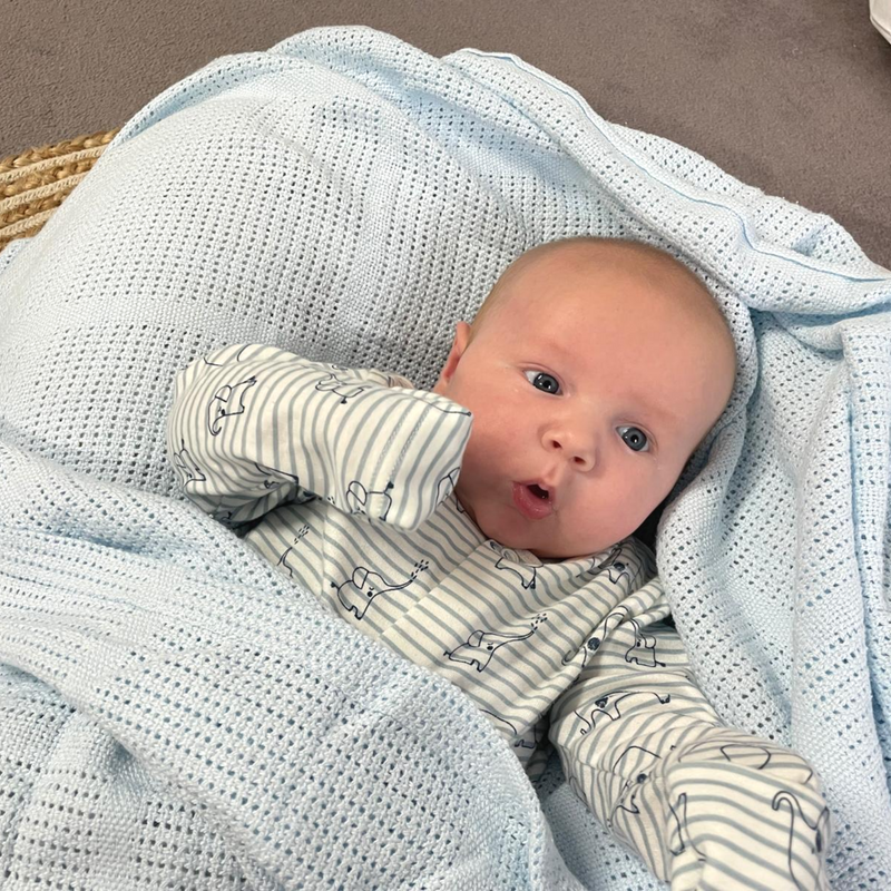 Happy baby in the Blue Soft Cotton Cellular Pram Blanket | Cosy Baby Blankets | Nursery Bedding | Newborn, Baby and Toddler Essentials - Clair de Lune UK