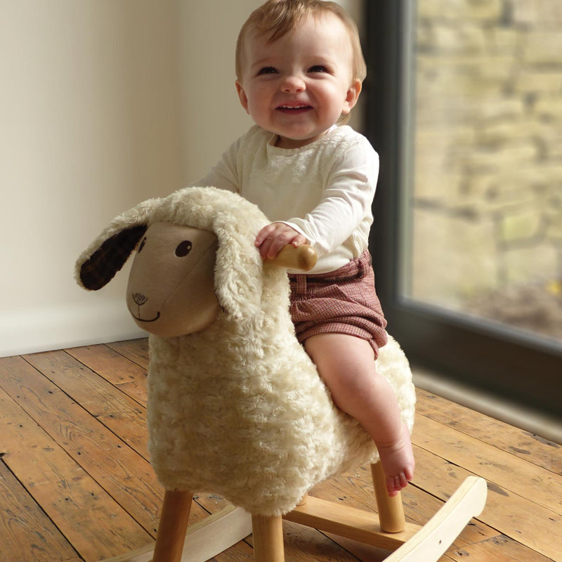  Toddler girl riding her favourite toy Little Bird Told Me Lambert Rocking Sheep in a traditional Cotswold cottage | Rocking Animals | Montessori Activities For Babies & Kids | Toys | Baby Shower, Birthday & Christmas - Clair de Lune UK