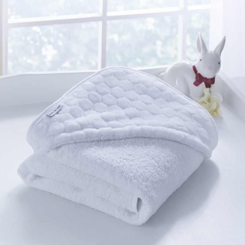 Folded White Marshmallow Hooded Towel for organising next to a white window in the bathroom | Baby Bathing & Changing Essentials - Clair de Lune UK