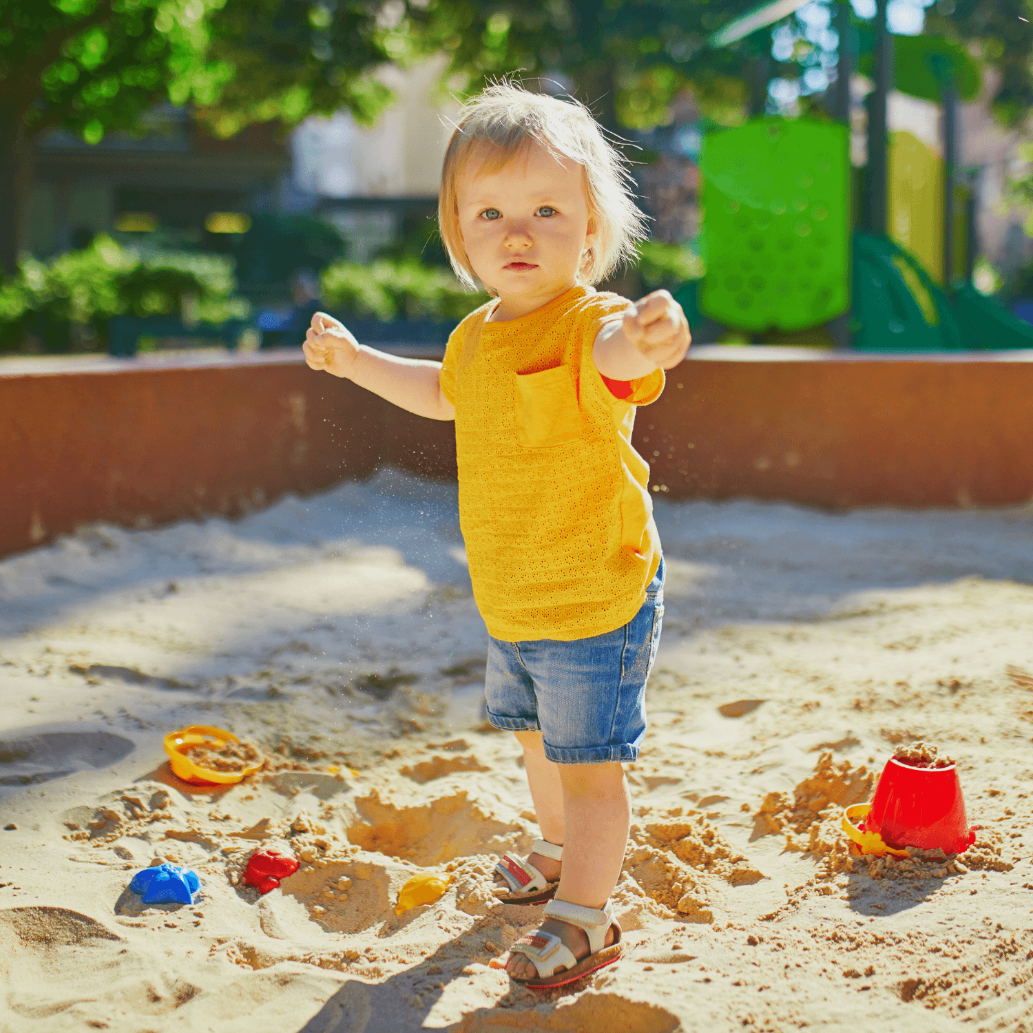 Toddler wearing shorts and t-shirt playing in the sandpit on a sunny summer day | News - Clair de Lune UK