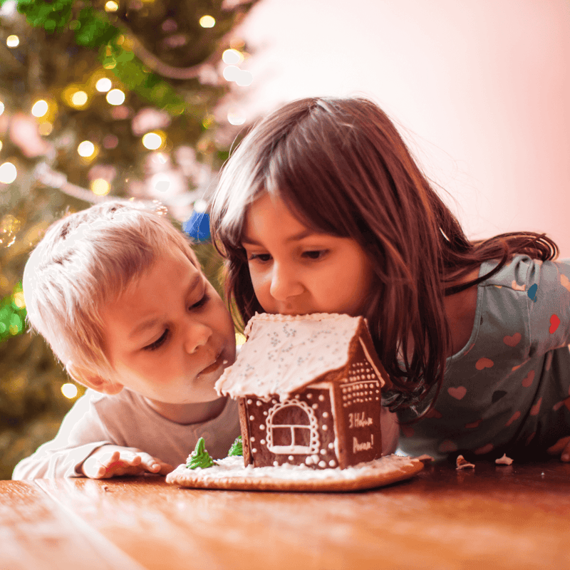 Boy and girl making and eating a gingerbread house | Family Christmas - Clair de Lune UK