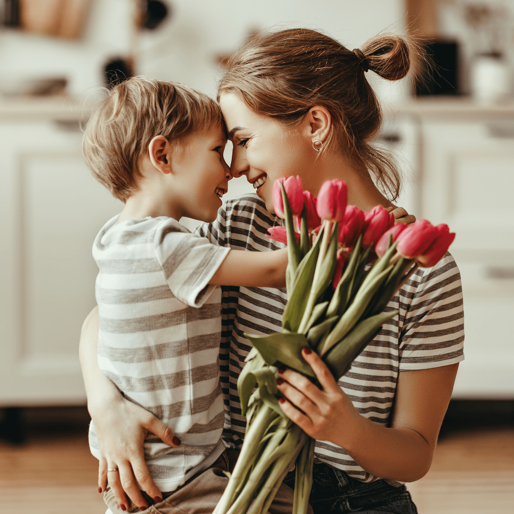 Mum and son wearing matching stripes t-shirts staring into each other's eyes with lots of love holding a bunch of tulips | Family Time | Mother's Day - Clair de Lune UK