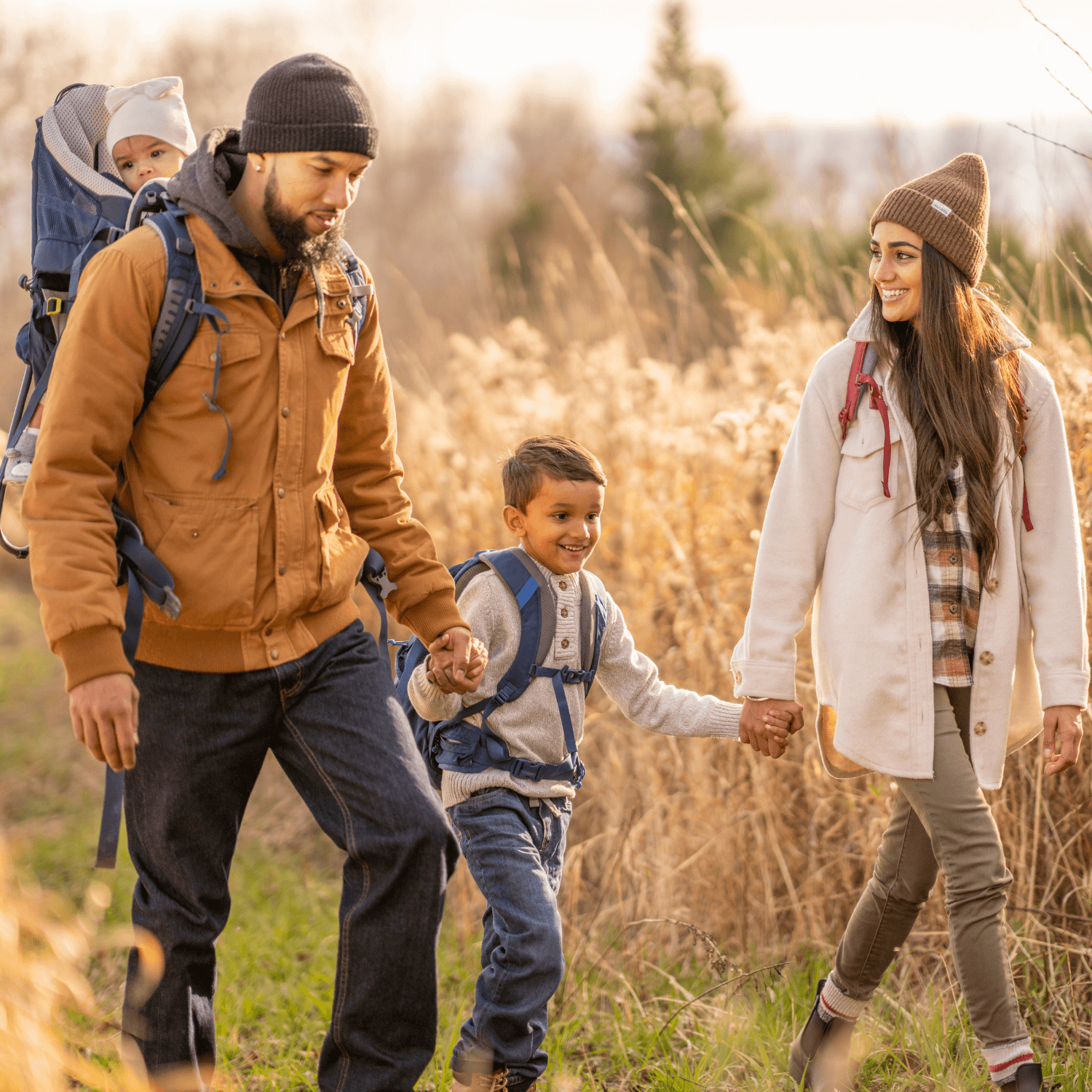 Mum, dad and toddler wrapped up in winter coats and hiking gear taking a stroll through the forest | Family New Year - Clair de Lune UK