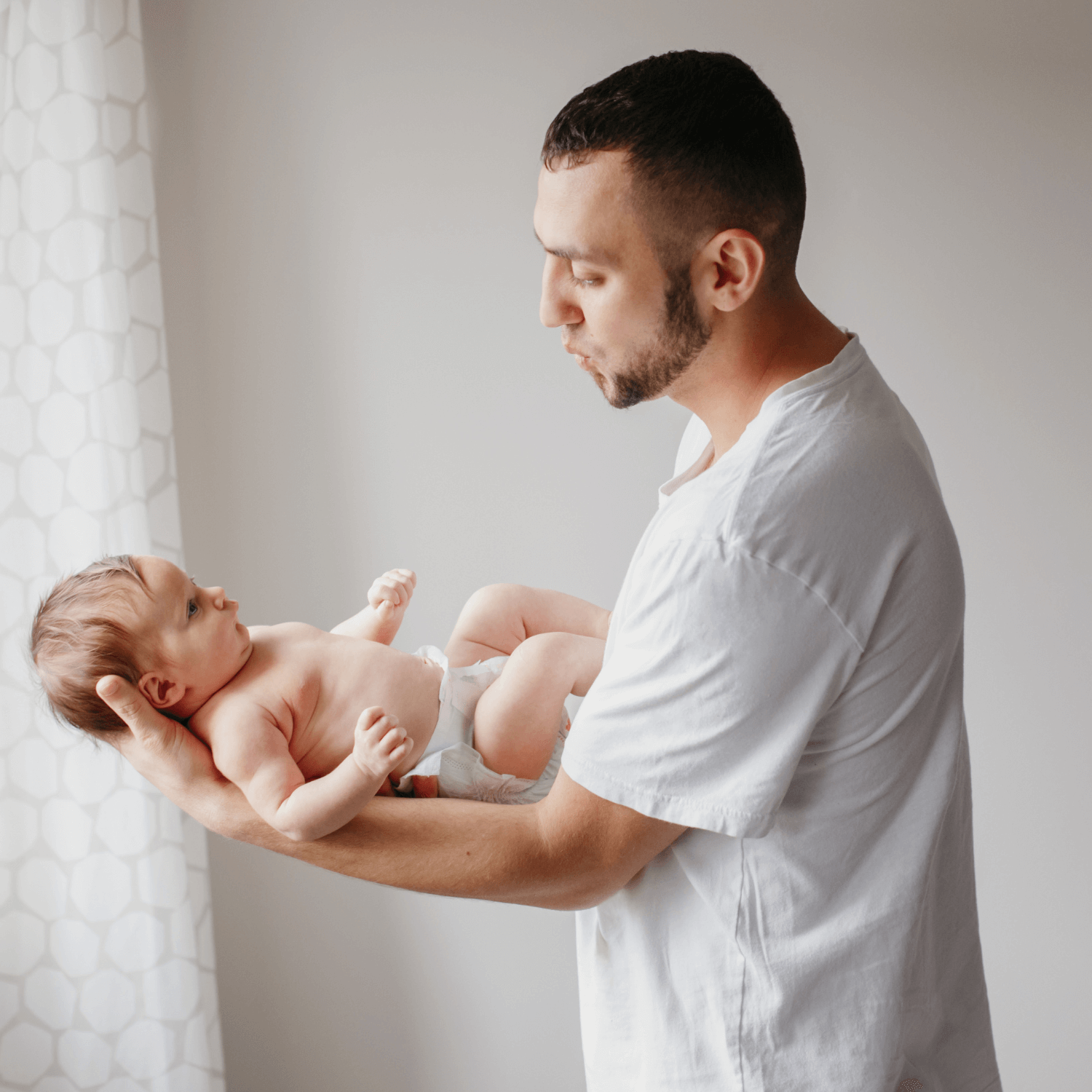 Dad wearing white shirt holding baby by the window | Father's Day | Gift Guide - Clair de Lune UK