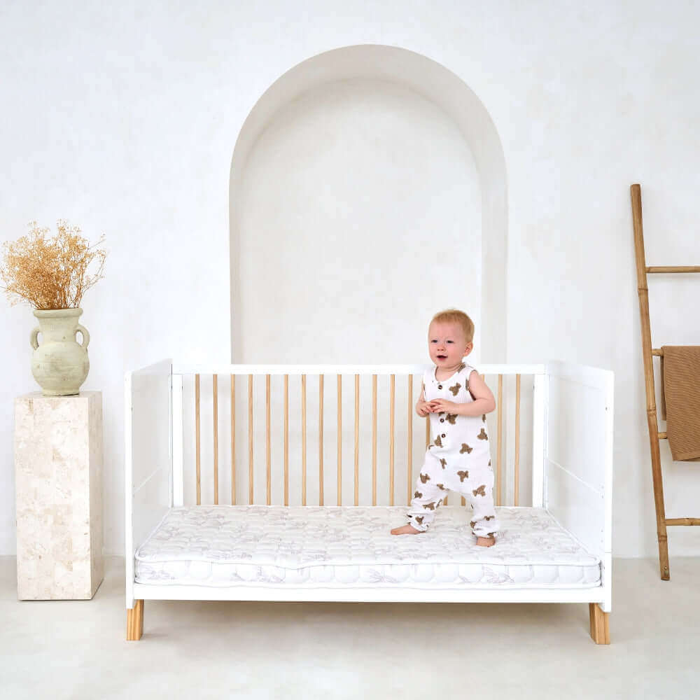 Toddler jumping on the mattress of the Essentials Cot Bed | Switch Your Baby from a Moses Basket to a Cot Bed - Clair de Lune UK