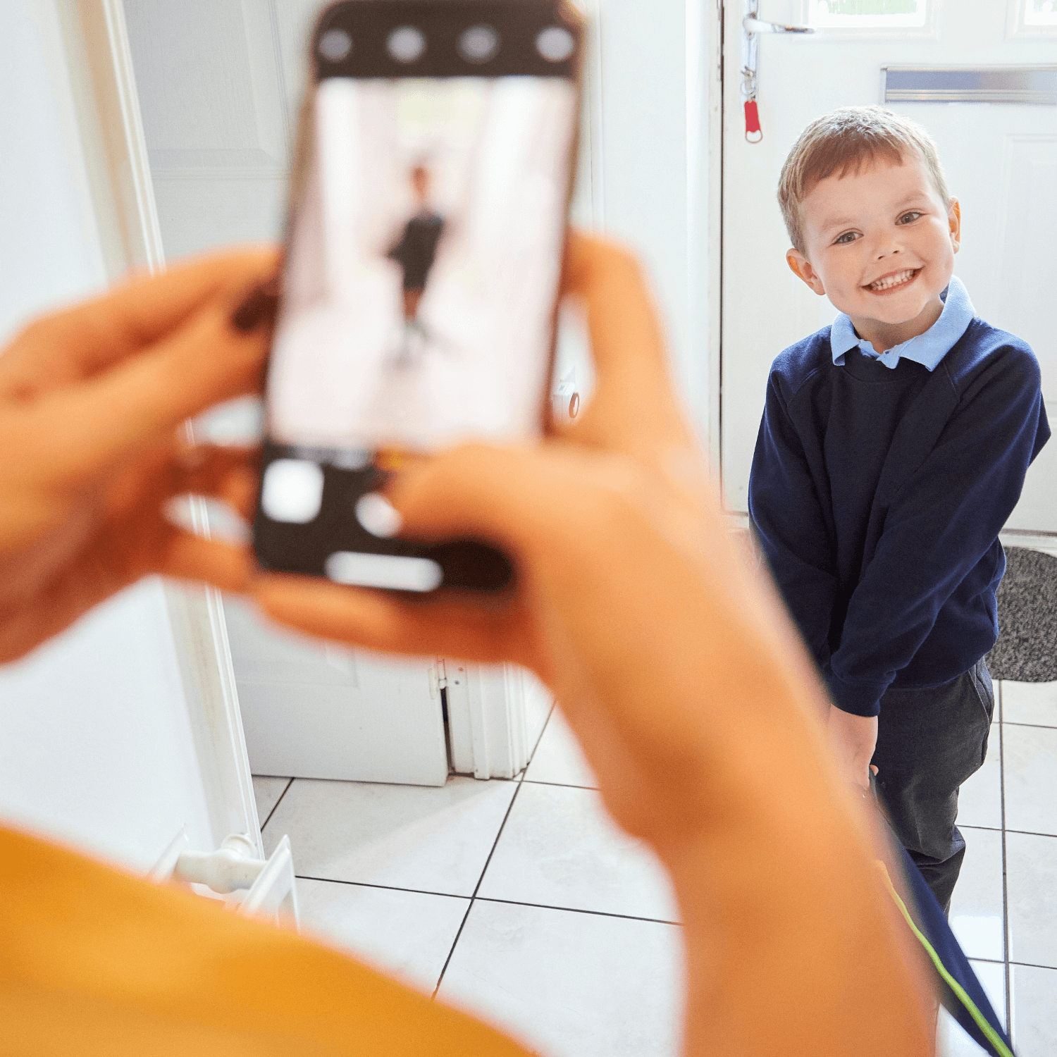 Mum taking a photo of her son in his blue school uniform on his first day of school | News - Clair de Lune UK