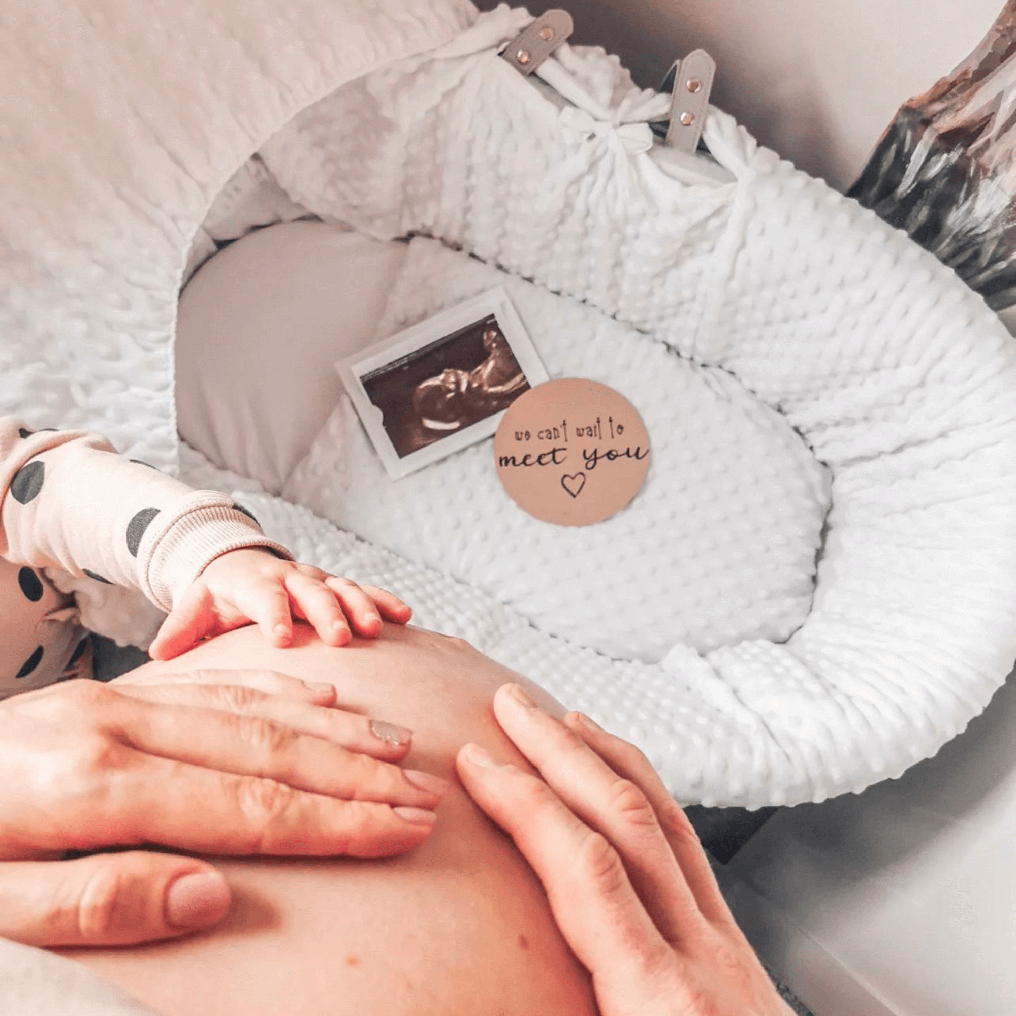 Pregnant mum holding her baby bump standing next to a Waffle Wicker Moses Basket | Bassinets and Cradles - Clair de Lune UK