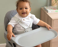 Happy baby dressed in white shirt sat in the 6in1 Eat & Play High Chair | Feeding & Weaning - Clair de Lune UK