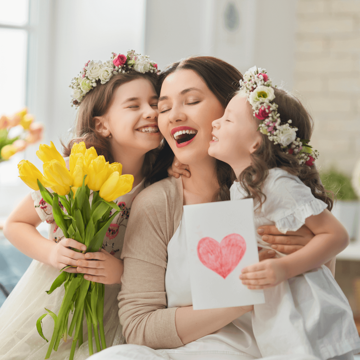 Celebrate Mother's Day with Adorable Craft Ideas | Two children hugging and kissing their mum while gifting a heart card and daffodils | Mother's Day - Clair de Lune UK