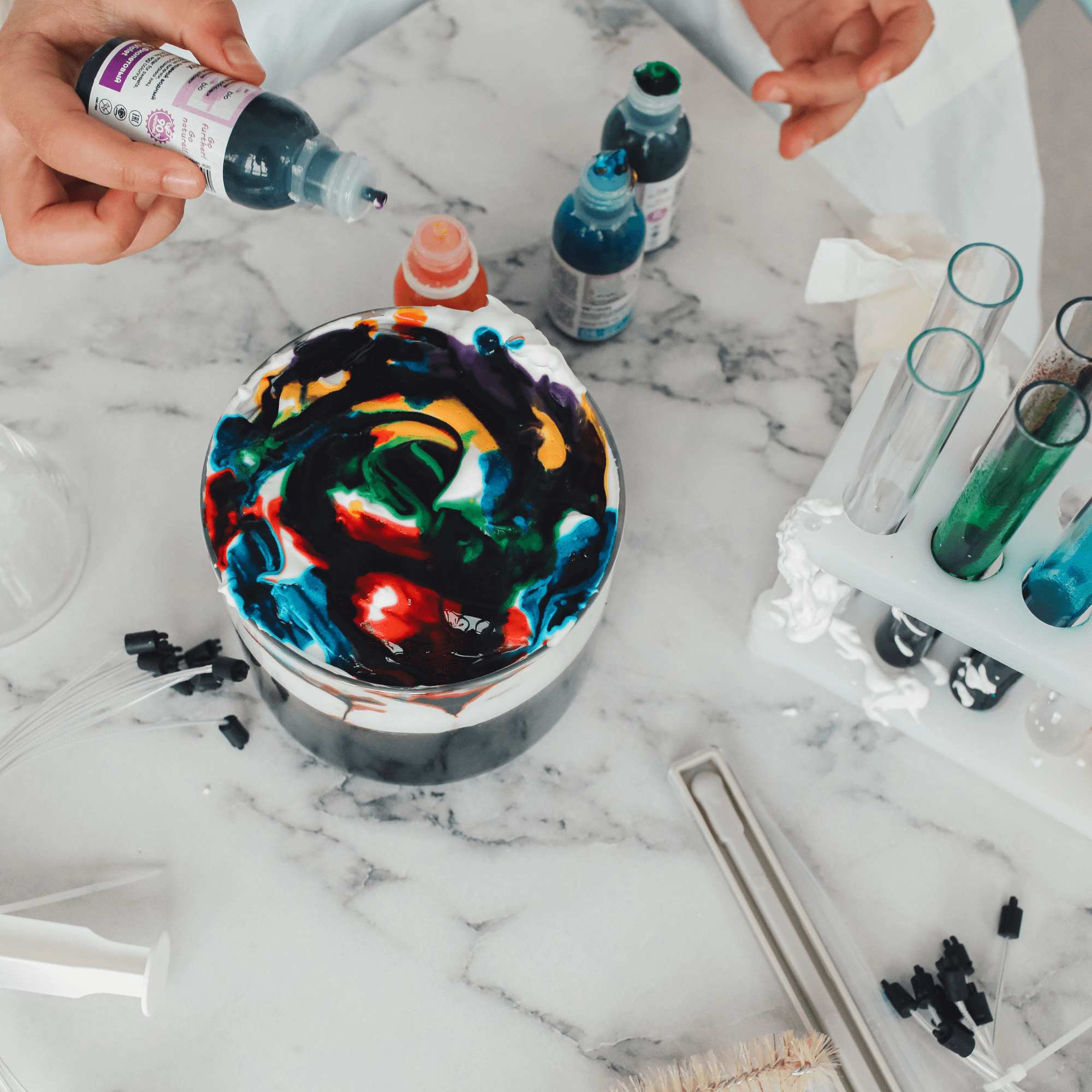 Child holding test tubes and pipettes doing a science experiment with shaving foam | Kids crafts - Clair de Lune UK