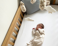 Baby wearing white onsie in the Savannah palm moses basket on a jute rug | Co sleepers - Clair de Lune UK