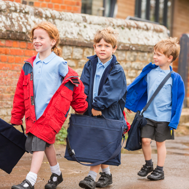 Children wearing school uniforms and winter coats holding book bags on the school run | Back to School - Clair de Lune UK
