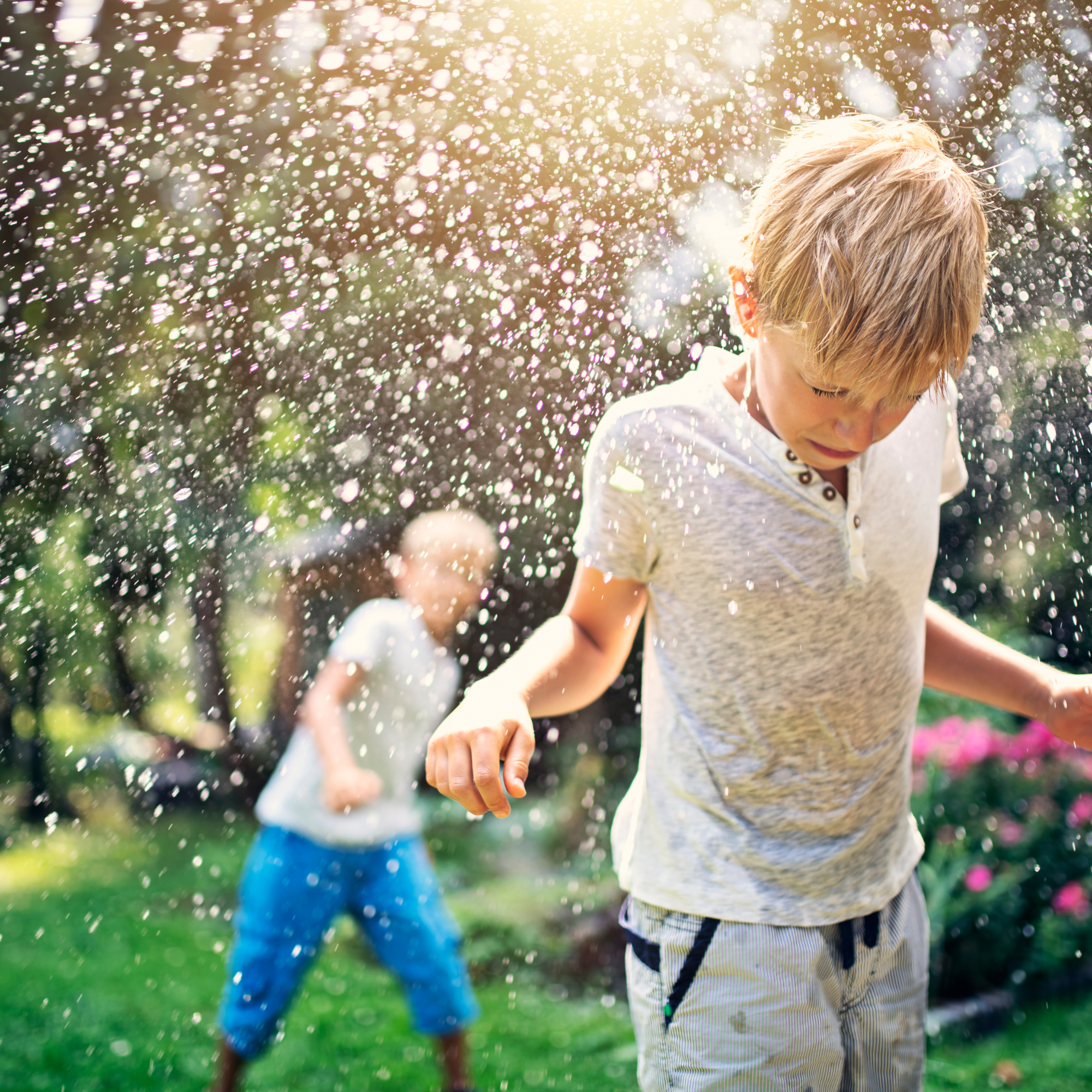 Two boys playing with water balloons in the garden and water splasing all around | Kids activities - Clair de Lune UK
