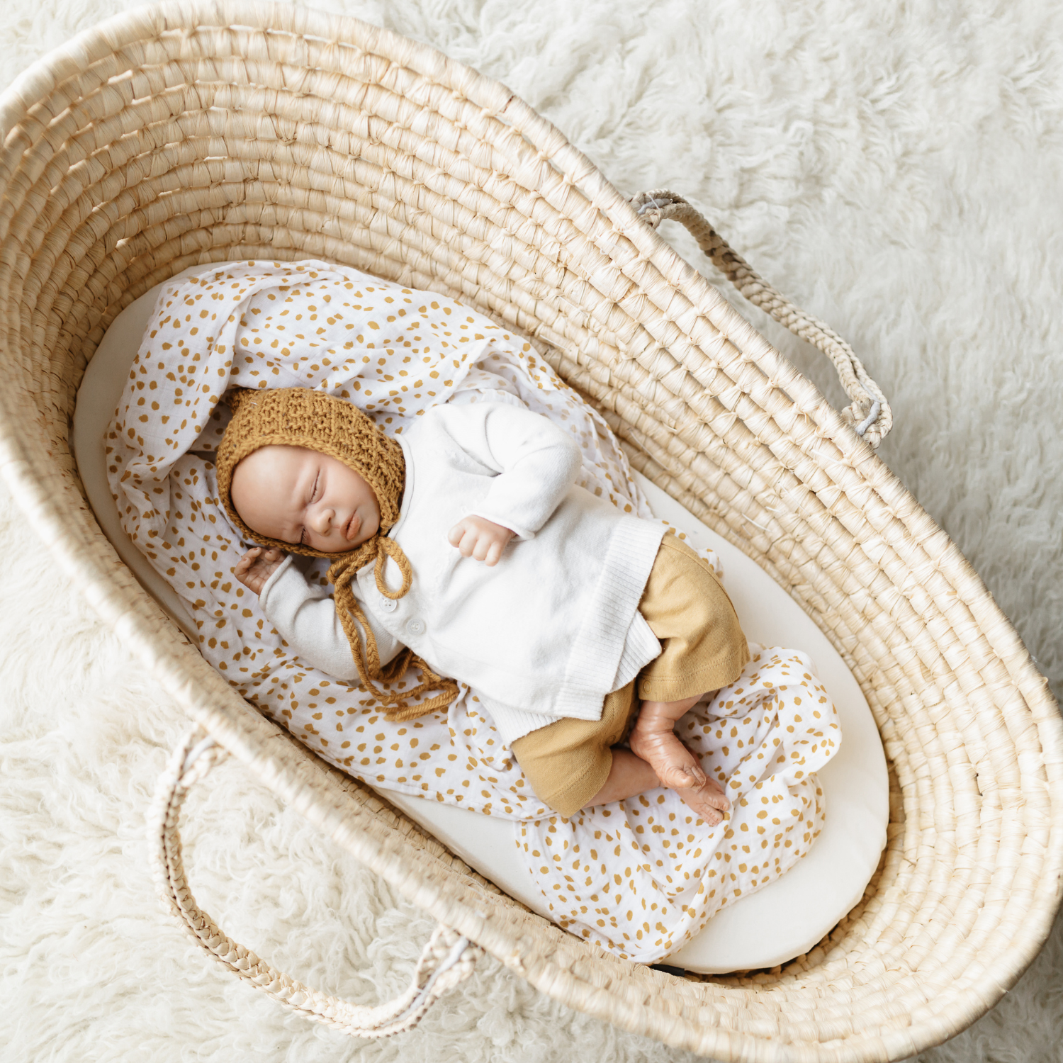Newborn lying on a white sheet in an undressed natural palm moses basket | Parenting tips and advice - Clair de Lune UK