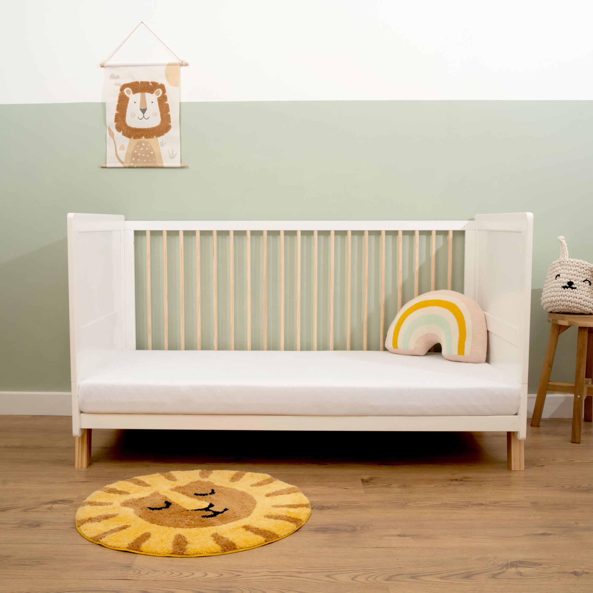 Essentials White Cot Bed with a baby rainbow cushion and cot mattress in sage green nursery | Nursery Furniture - Clair de Lune UK