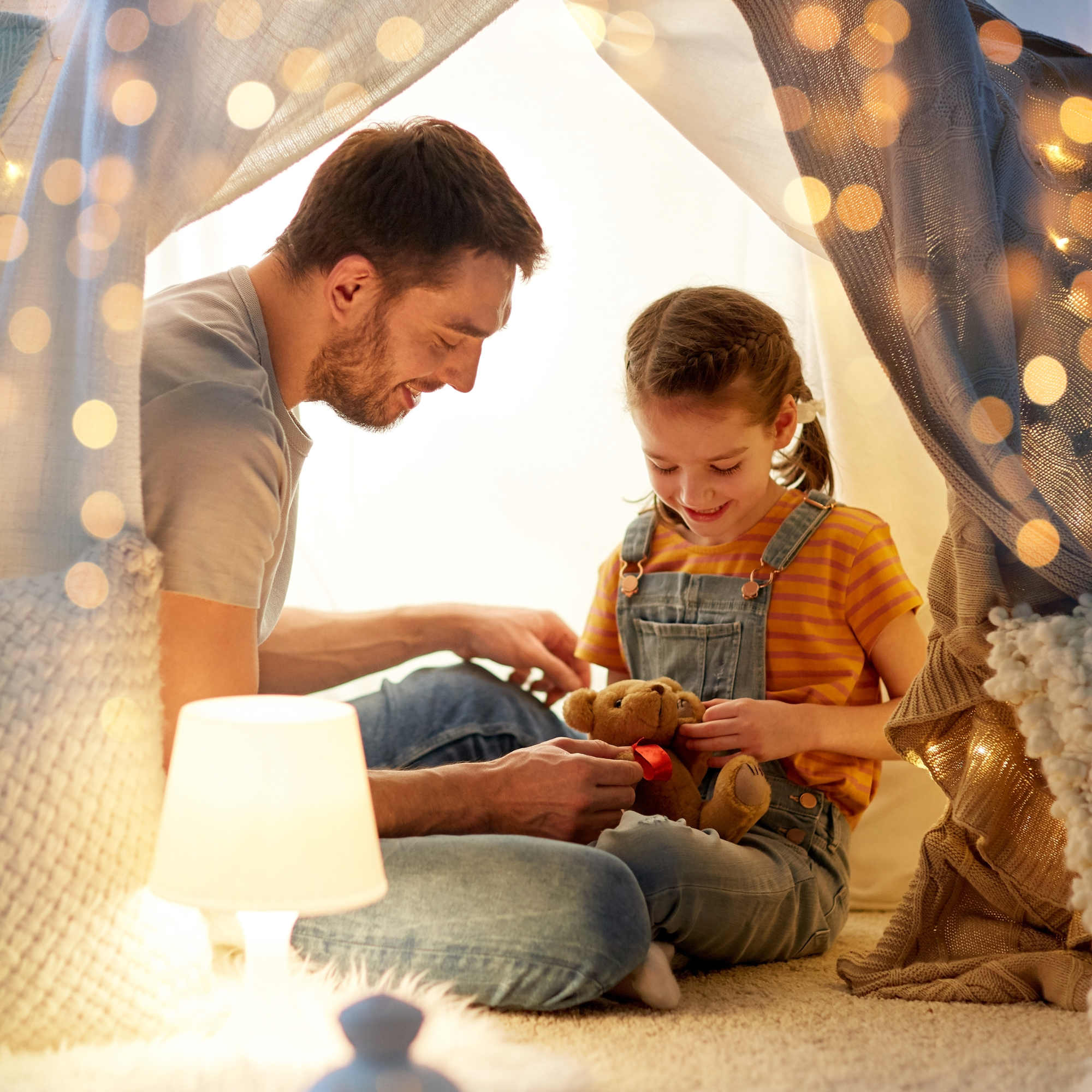 Dad and daughter sitting in a beautiful homemade den light up with fairy lights having a teddy bear's picnic | Family Time | Father's Day - Clair de Lune UK