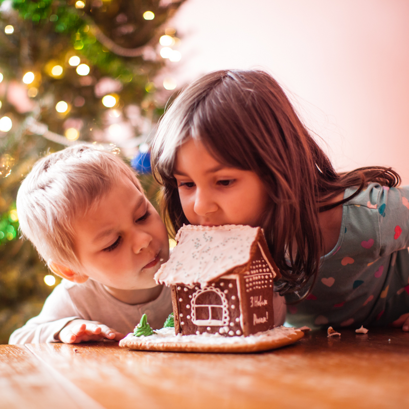 Boy and girl making and eating a gingerbread house | Family Christmas - Clair de Lune UK