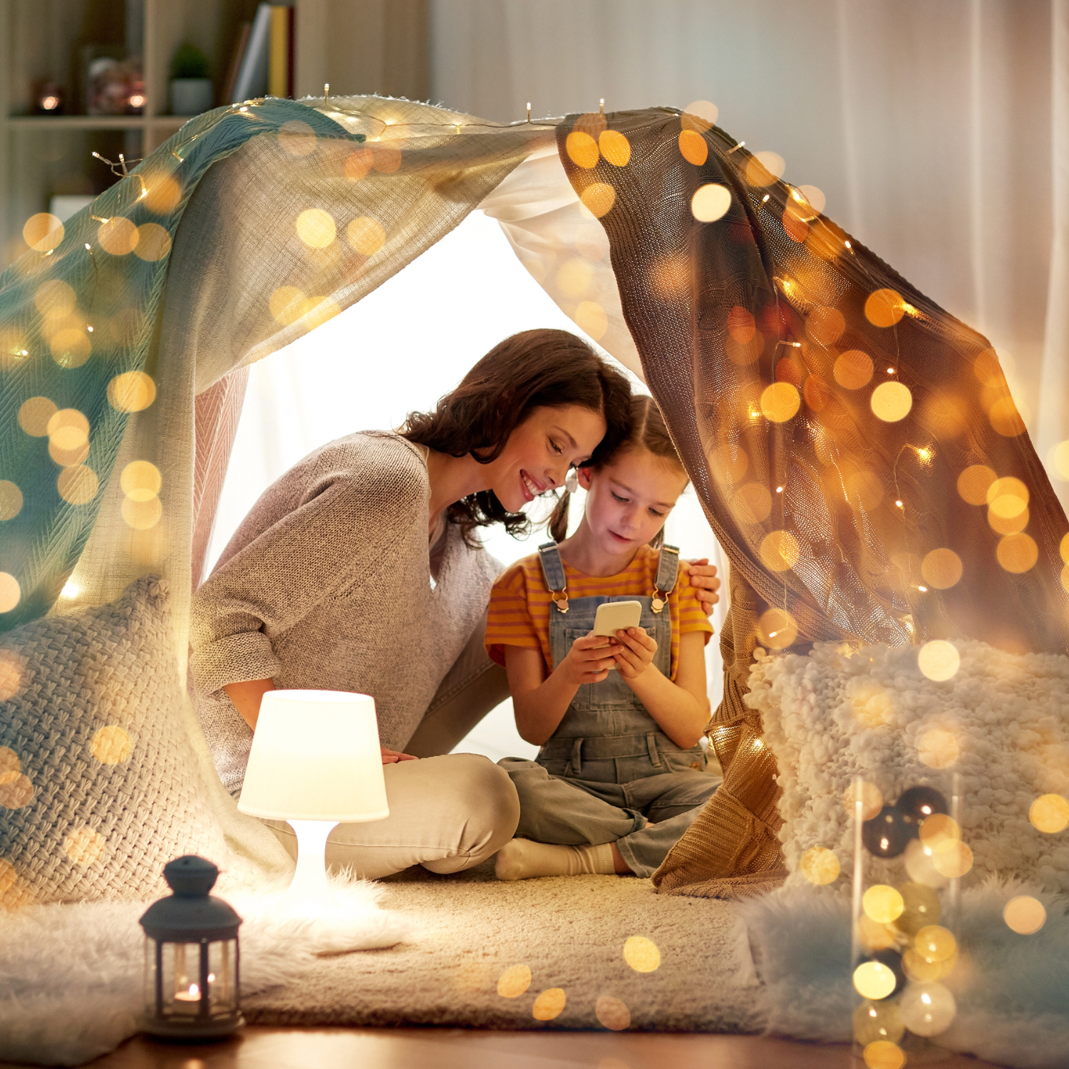 Family next to the Christmas tree in a homemade blanket fort covered in fairy lights | Family Christmas - Clair de Lune UK