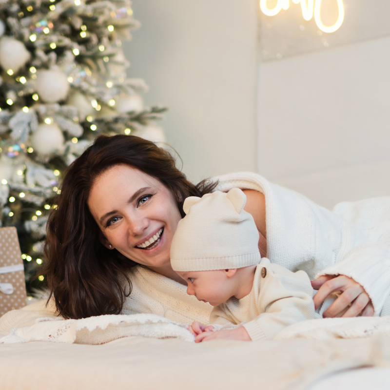 Mum and baby reading in front of the Christmas tree | Family Christmas - Clair de Lune UK