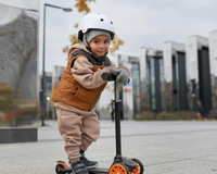 Toddler boy wearing safety helmet riding scooter in an urban city centre | Outdoor childrens toys - Clair de Lune UK