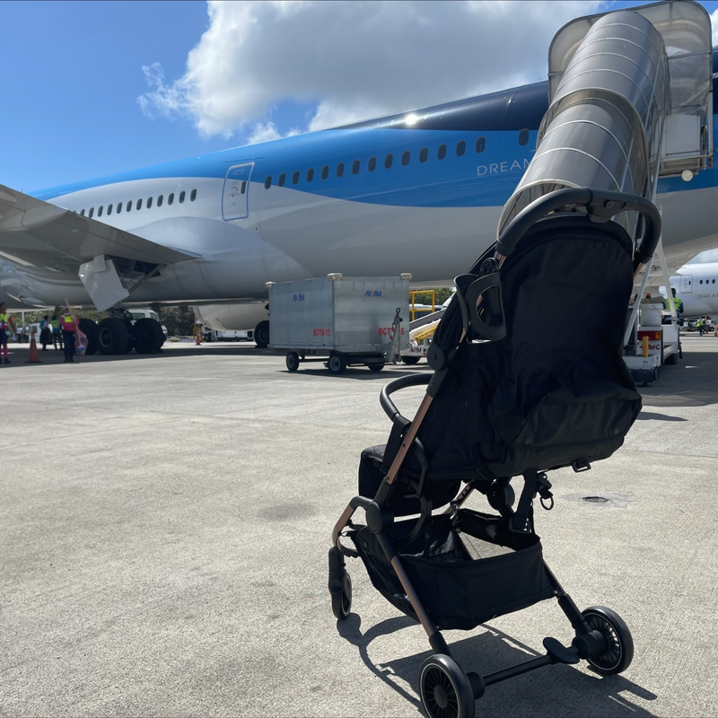 Baby in a cabin-friendly stroller in front of a plane at the airport | Pushchairs - Clair de Lune UK