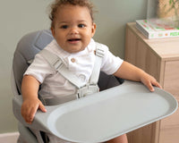Happy baby dressed in white shirt sat in the 6in1 Eat & Play High Chair | Feeding & Weaning - Clair de Lune UK