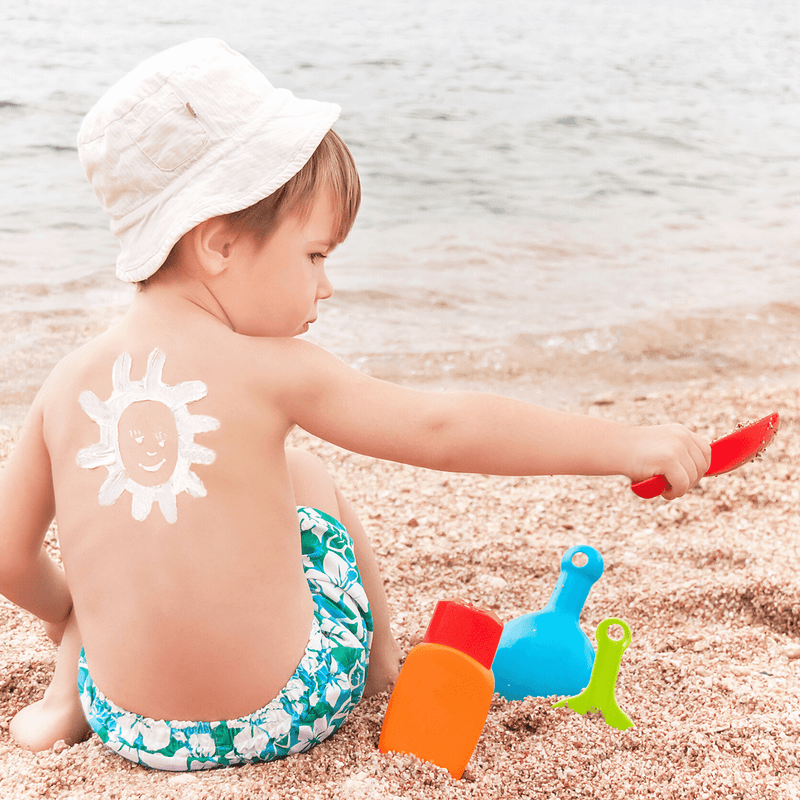 Beautiful baby girl wearing a white sun hat in the park | Summer Fun | Sun Safety - Clair de Lune UK