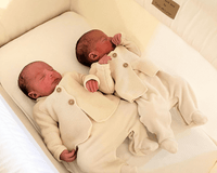 Twin newborn babies wearing cream onesies asleep in a Clair de Lune Organic Breathable Folding Crib in cream - Co-sleepers - Bedside Cribs