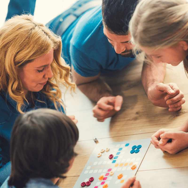 Family concentrating intently on games night | Family New Year - Clair de Lune UK